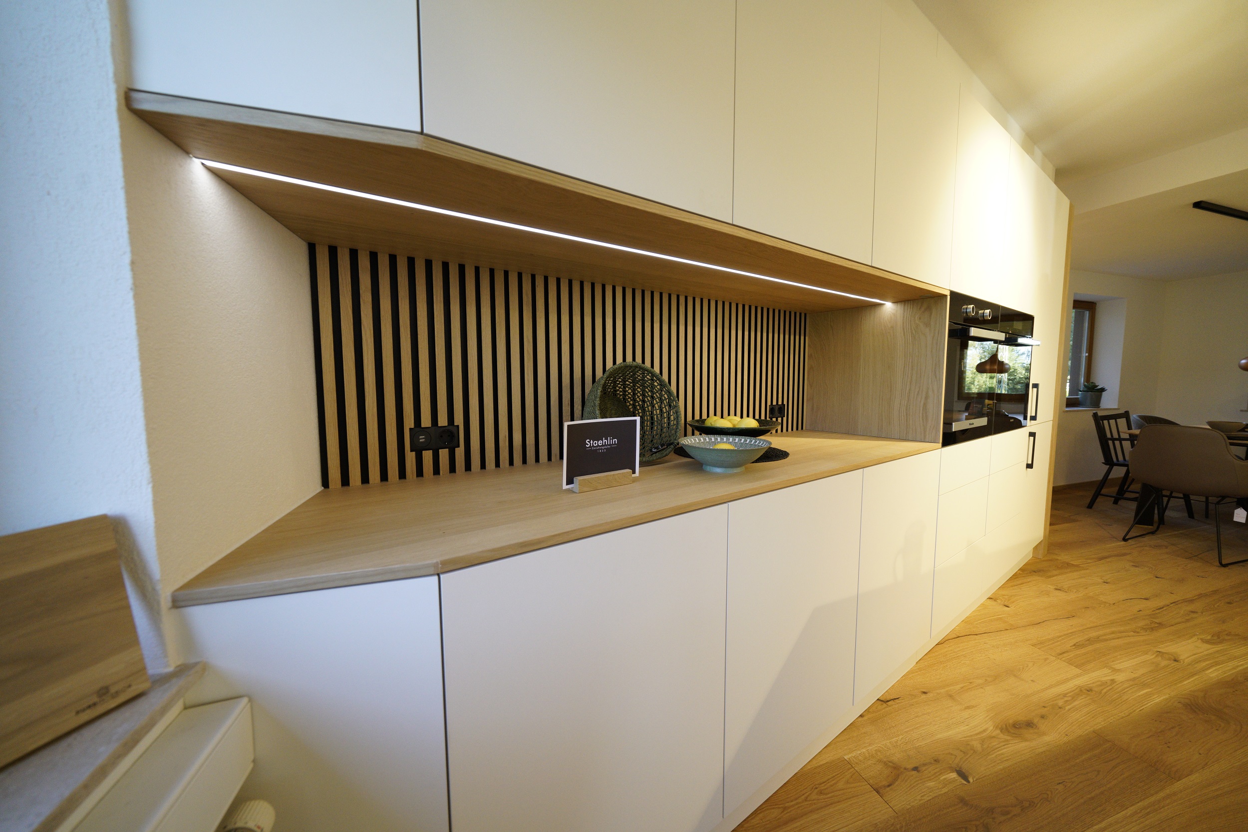 Küchenzeile in weiß matt mit Eiche-Küchenrückwand, LED-beleuchtet